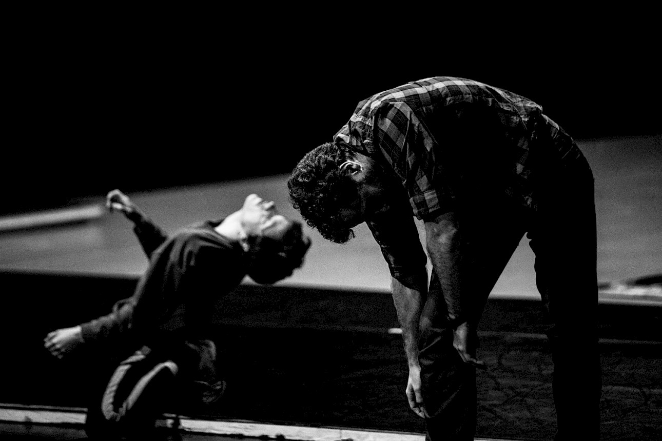 ALKANARA - Fotografia a preto e branco de duas pessoas num palco durante uma apresentação; uma inclina-se para a frente, enquanto a outra se curva dramaticamente para trás. - ©Filipe Ferreira