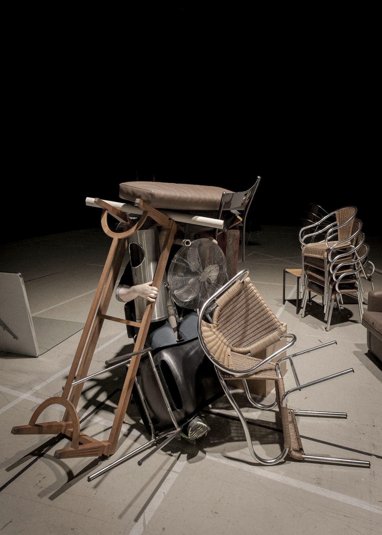ALKANARA - Vários objetos como cadeiras, cinzeiros de rua, sapataeiras, e mãos de manequim, amontoados num fundo preto. - ©João Tuna